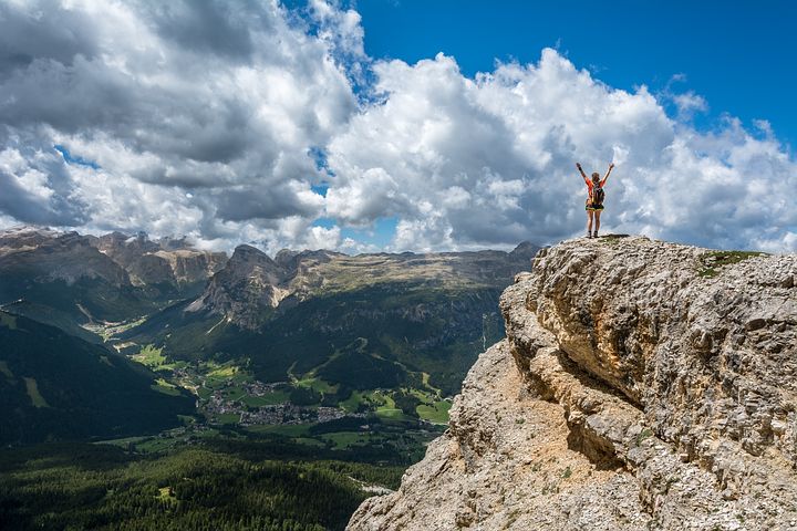 une personne en haut d'une montagne surplombant une vallée magnifique